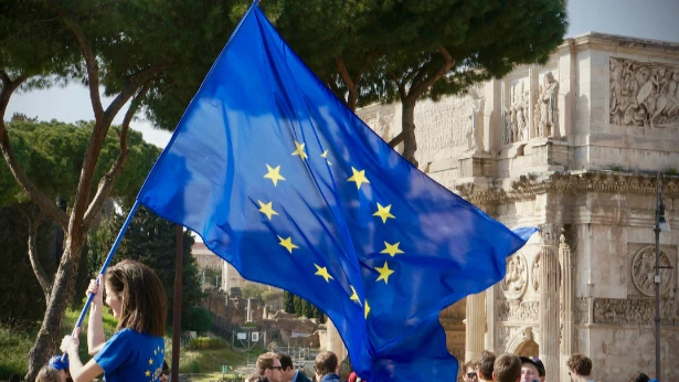Jeune femme brandissant un drapeau de l'Union Européenne lors d'un rassemblement